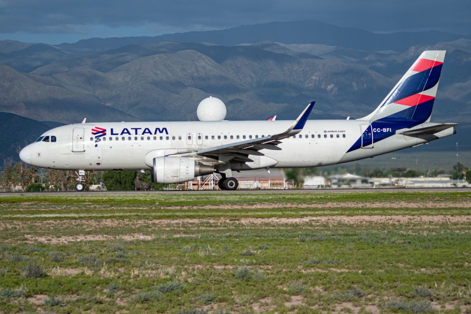 A LATAM Airlines Airbus A320 aircraft taxiing on a runway with mountains in the background. Perfect for travel and aviation themes.